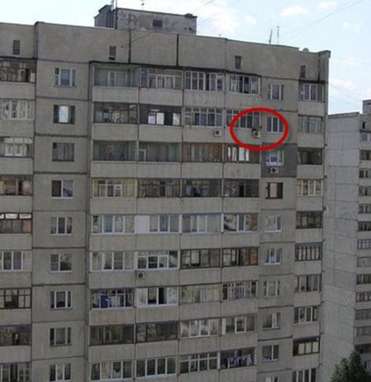 man sat installing aircon on a very very tall building 