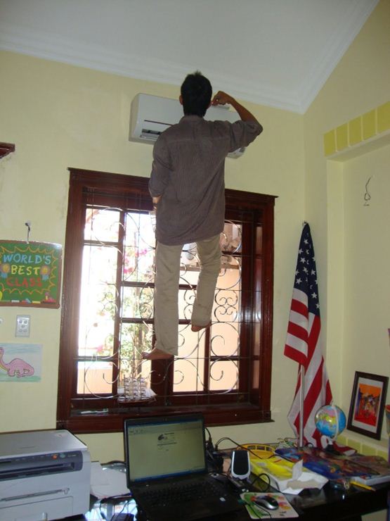 man stood on window installing aircon