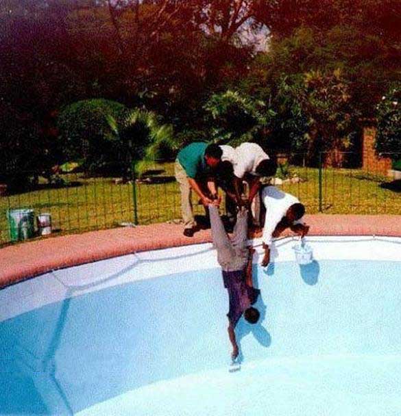 man held upside down painting pool