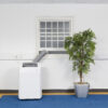 White Airconco 4.1kW portable air conditioner in an office with hose going out the window.