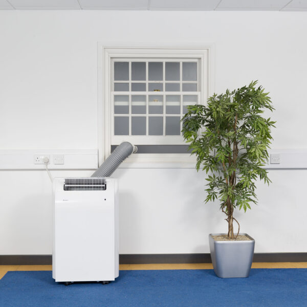 White Airconco 4.1kW portable air conditioner in an office with hose going out the window.