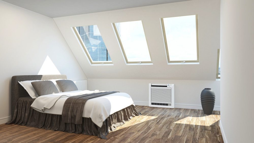 Aire acondicionado de pared bajo blanco instalado en una conversión de loft en un día soleado